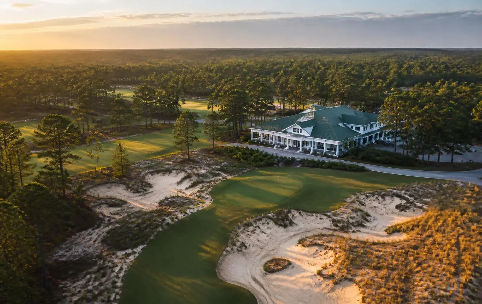 Aerial view of a championship golf course and clubhouse in the North Carolina Sandhills near Pinehurst at golden hour.