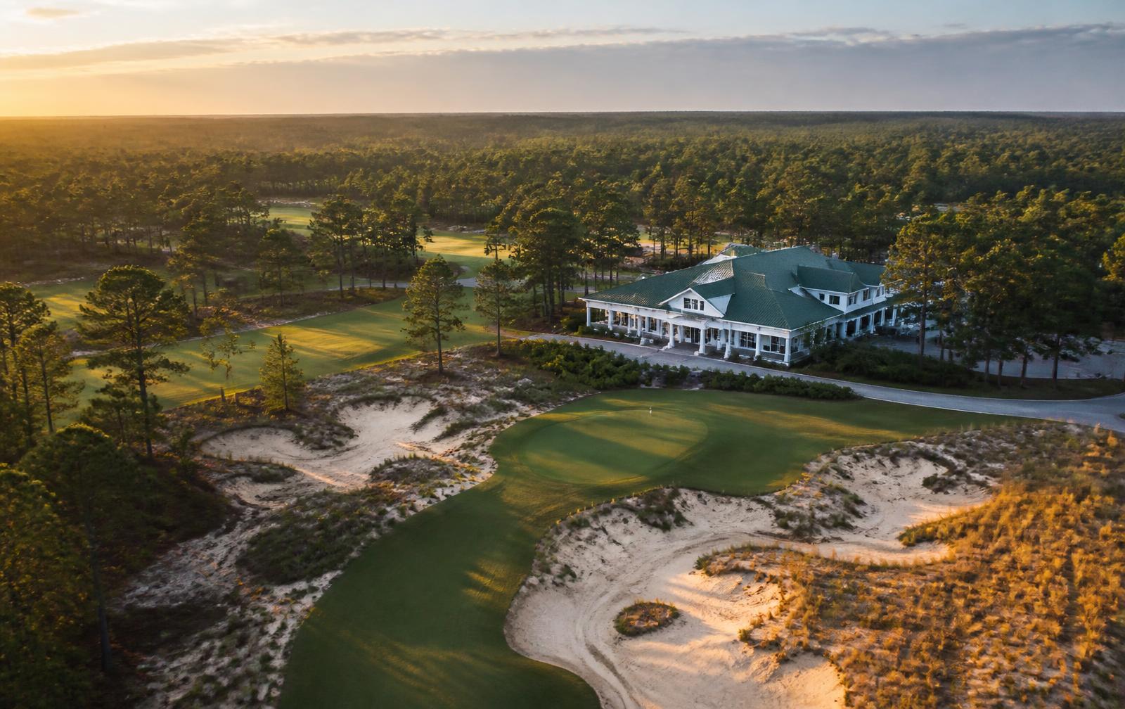 Aerial view of a championship golf course and clubhouse in the North Carolina Sandhills near Pinehurst at golden hour.